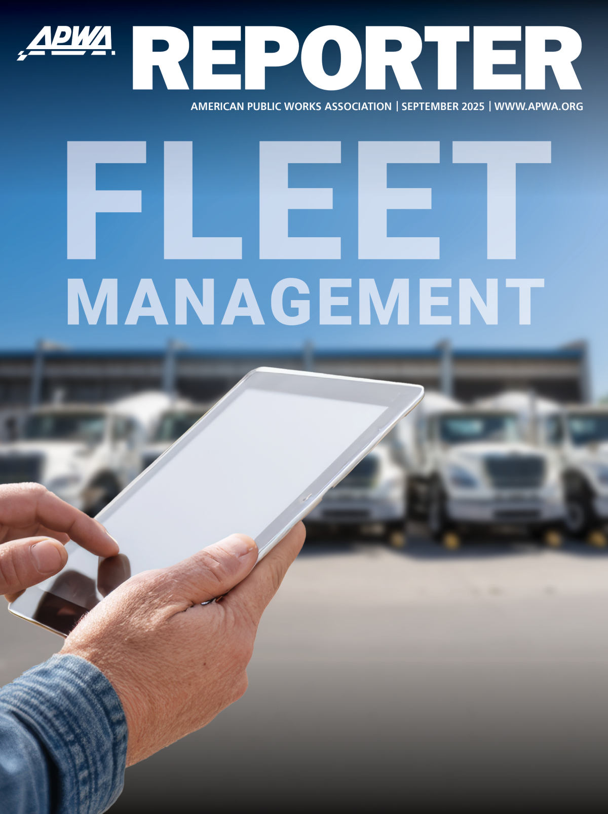 Hands manipulate a tablet as a fleet of trucks is parked in the background.