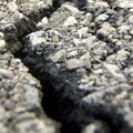 Dark asphalt road with cracks